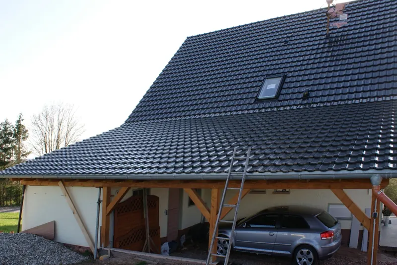 Carport aus Holz mit Ziegeldach am Wohnhaus