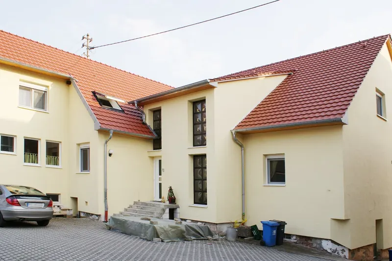 Mehrfamilienhaus mit neu eingedeckten roten Ziegeldächern und Gauben