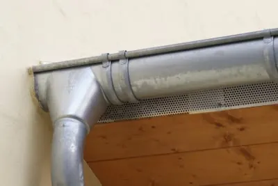 Dachrinne mit Fallrohr an holzverschaltem Dachüberstand