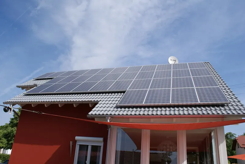 Photovoltaikanlage auf einem Einfamilienhaus mit rotem Anstrich