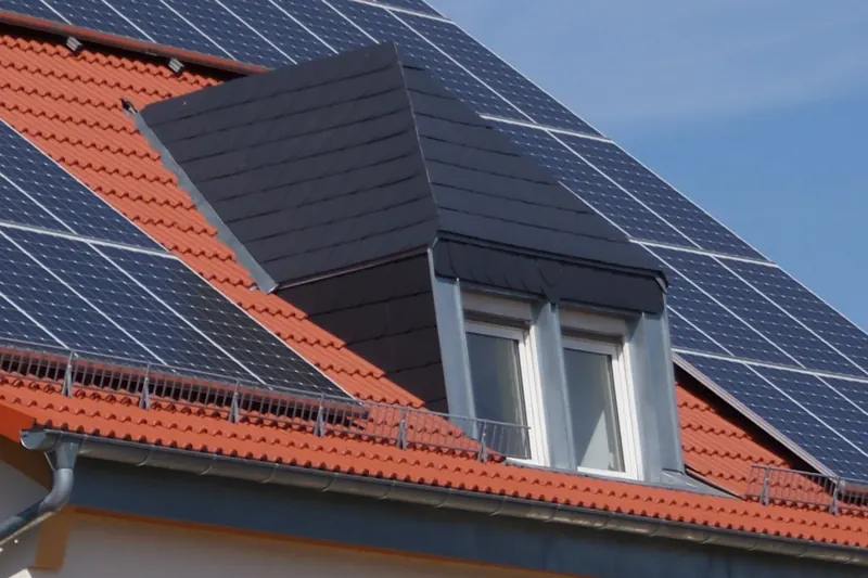 Photovoltaikanlage neben einer verkleideten Gaube auf Ziegeldach